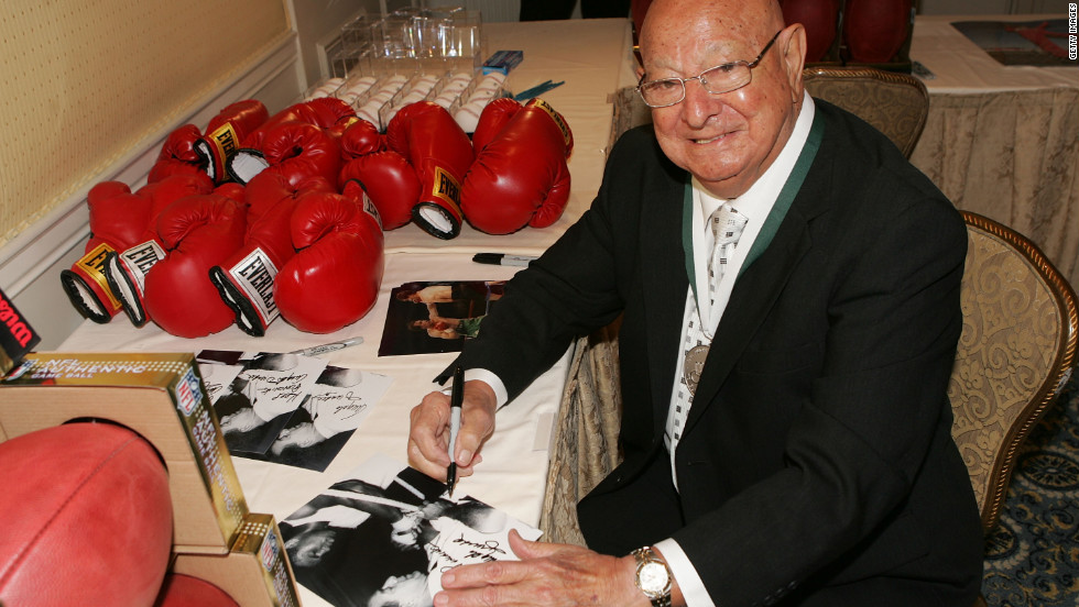 Dundee signs memorabilia at the 23rd Annual Great Sports Legends Dinner to Cure Paralysis in New York in September 2008. 