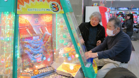 Tsuneko Kataoka, left, watches as another older gamer plays a game.