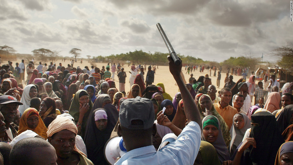 A security officer keeps order in Dadaab as hundreds of desperate people try to move to a less crowded refugee camp set up three days&#39; drive away.
