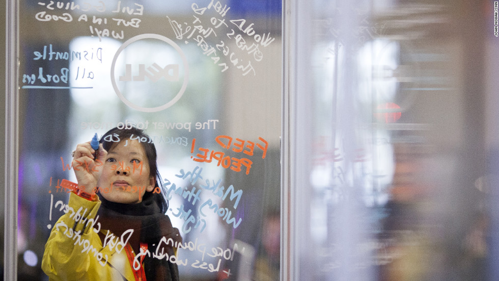 An attendee scrawls a message on a transparent board.