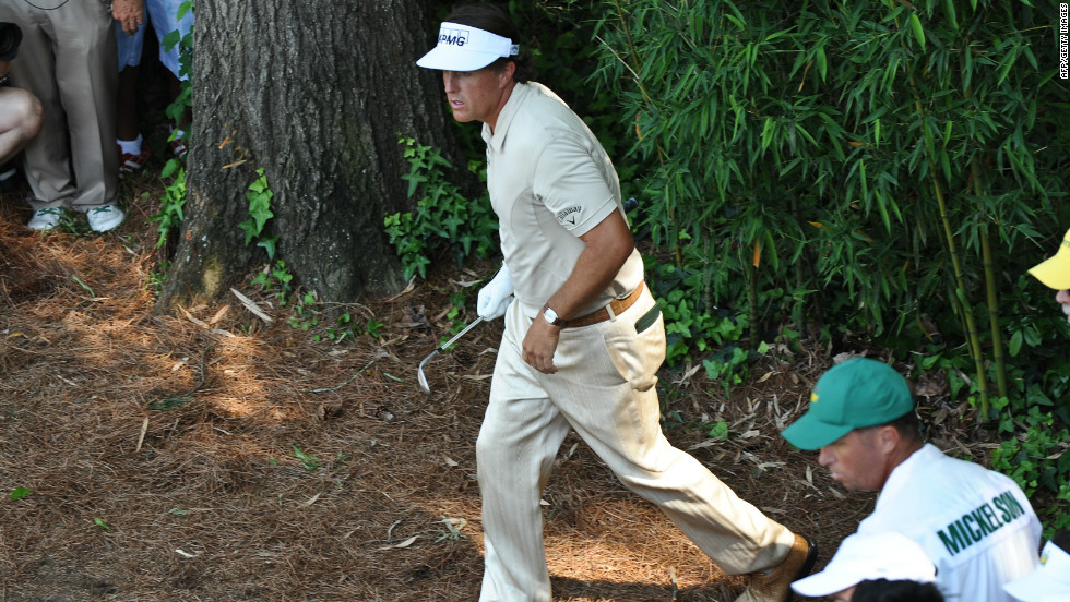 Phil Mickelson watches his shot from the rough at the fourth on the way to a triple bogey.