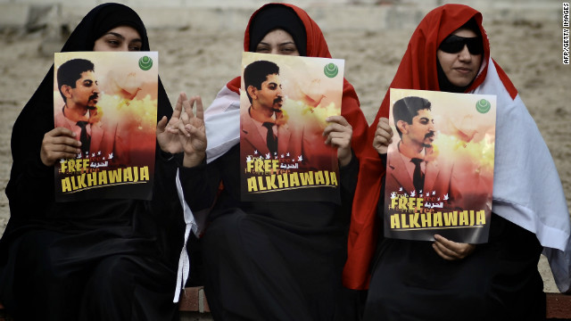 Bahraini demonstrators hold posters of Abdulhadi al-Khawajah, one of 13 defendants accused of attempting a coup. 