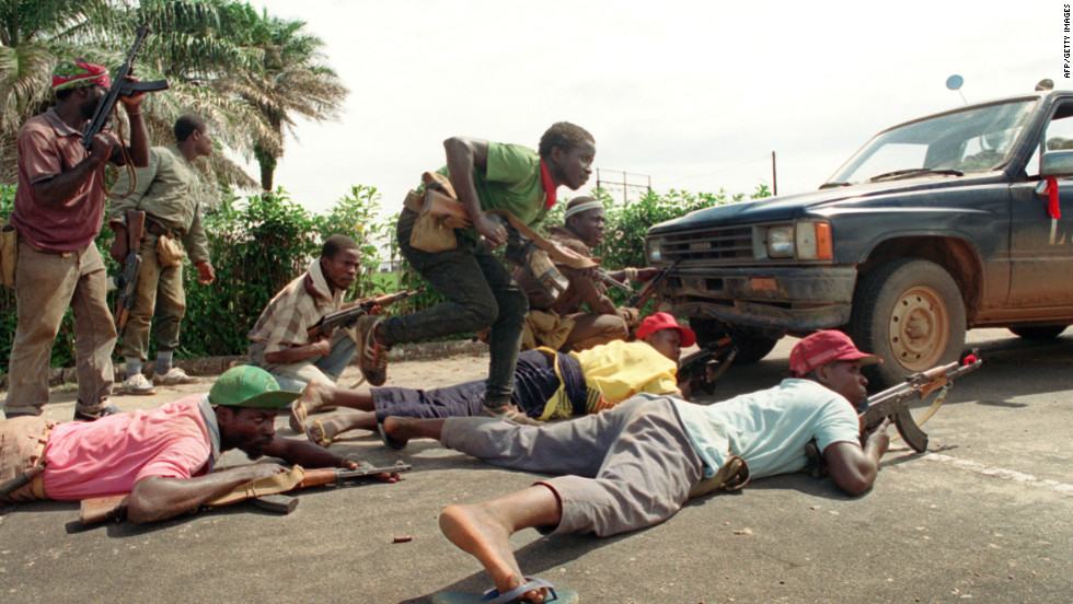 Rebels loyal to Charles Taylor take position behind a truck in May 1990 in Monrovia.