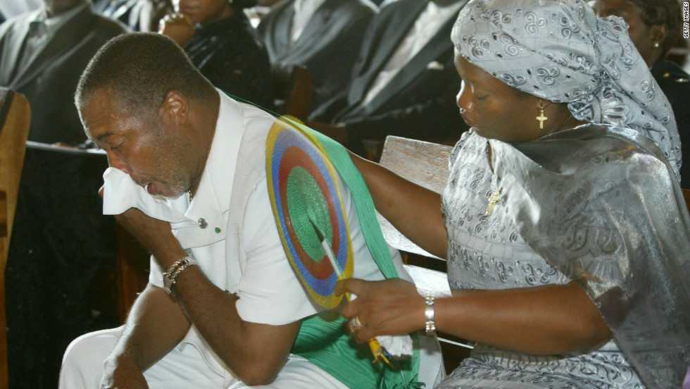 Charles Taylor is comforted by his wife, Jewel Howard-Taylor, at the funeral of his mother in July 2003 in Monrovia.
