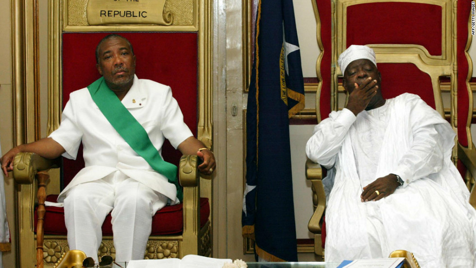 Charles Taylor, left, sits beside Liberia&#39;s new President Moses Zeh Blah during a swearing-in ceremony in Monrovia in August 2003.