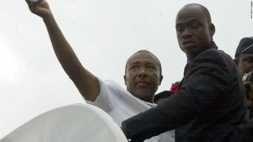 Charles Taylor waves as he boards a Nigerian government plane in Liberia August 2003 that will take him into exile.