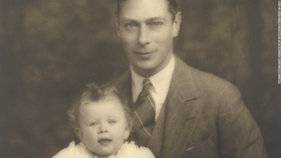 Prince Albert, later King George VI, proudly sits for a photograph with his young daughter and future monarch, Elizabeth.