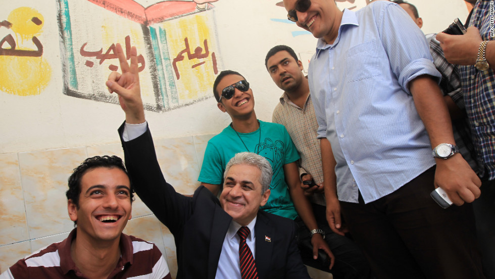 Presidential candidate Hamdeen Sabahy, a leftist dark-horse contender, flashes a sign of victory as he waits to vote at a Cairo school.