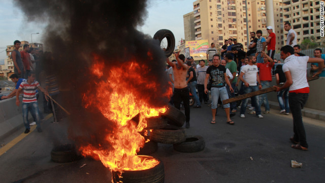 Shiite Muslim youths set tires on fire to block a road at the entrance of Beirut&#39;s southern suburbs on Tuesday. 