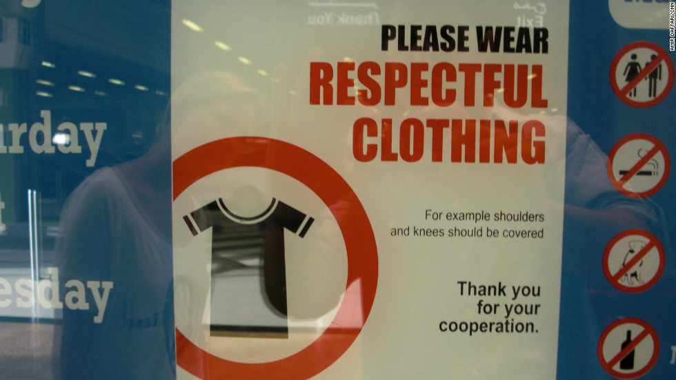 Signs in shopping malls remind visitors to cover their knees and shoulders. Some people say security guards should go further and ban or fine those who refuse to cover up.