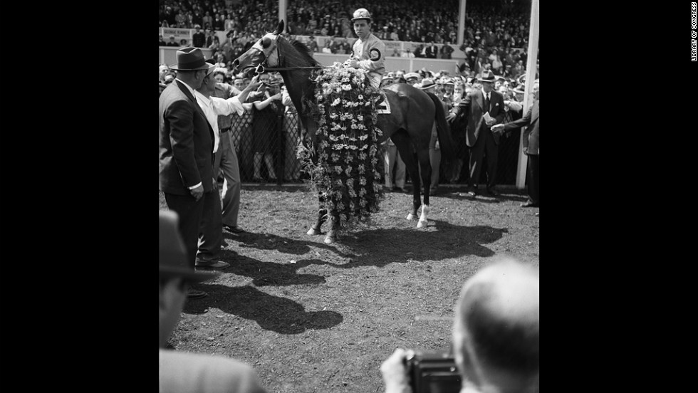 Count Fleet, who won the Triple Crown in 1943, is adorned with flowers after winning the Preakness that year.