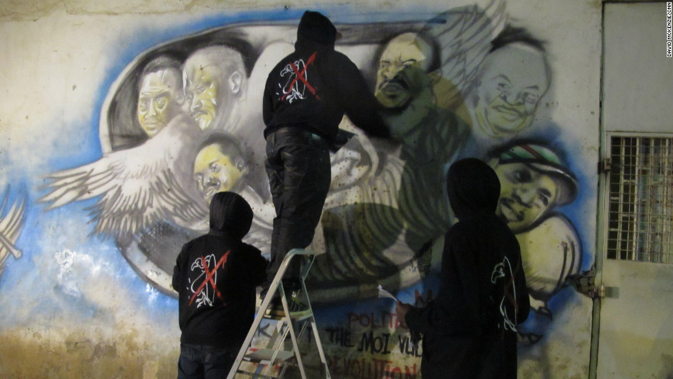 Graffiti artists work on the details of their latest piece in Nairobi, Kenya. They paint political art highlighting corruption and compare national leaders to vultures.