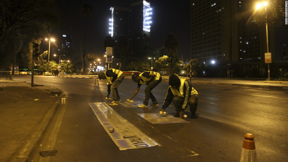 Kenyan graffiti artists put down traffic cones and road markings when they are painting to make the sites appear official.