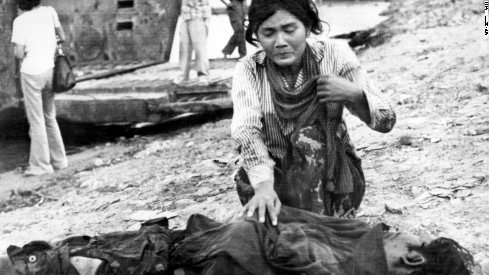 A woman cries next to a dead body in April 1975 in Phnom Penh, after the Khmer Rouge enter the Cambodian capital and establish the government of Democratic Kampuchea (DK).