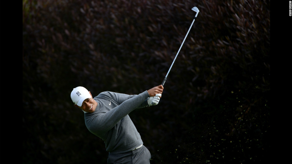 Woods, who was leading his group, hits his tee shot on the 13th hole Thursday.