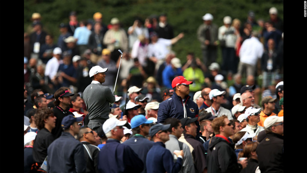 Surrounded by spectators, Woods watches a shot on the 18th tee.