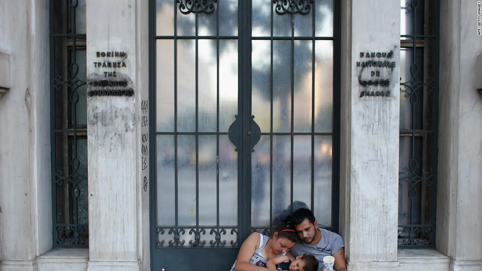 A family beg on the street in front of the National Bank in Athens. Greece is facing its fifth year of recession.