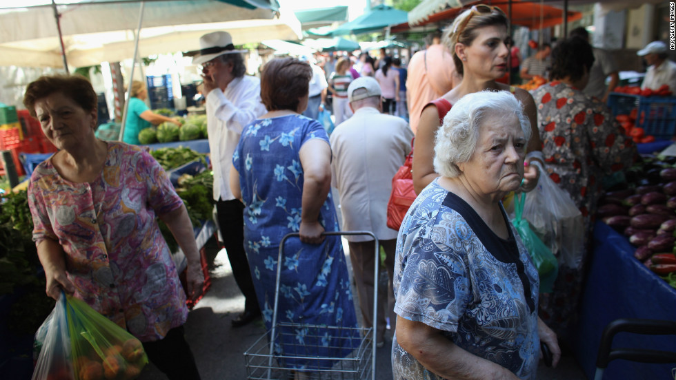 Greek people buy fruit and vegetables from a market in Omonoia on June 12, in Athens. After nearly three years of austerity measures, some Greeks say it is a struggle to continue feeding their families.