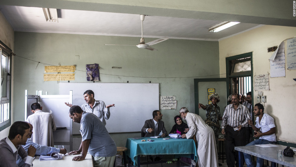 Election officials and an Egyptian soldier direct voters during the second stage of runoff presidential elections at a polling station in Giza.
