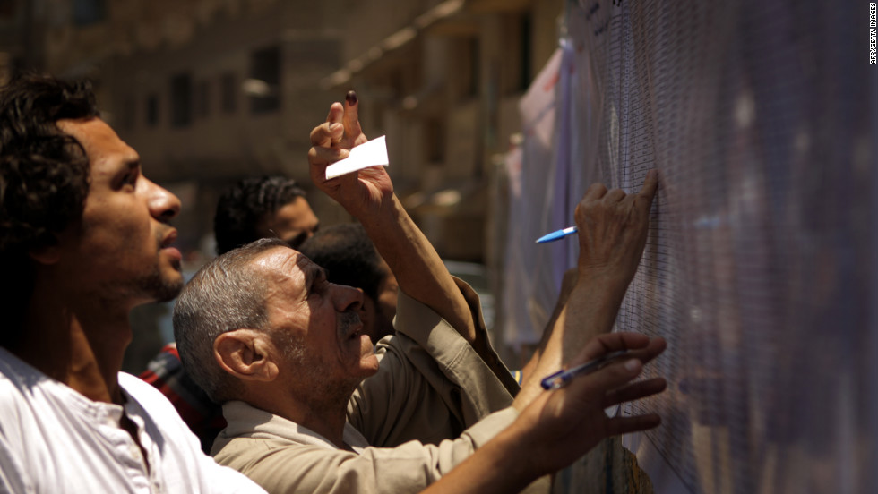 Egyptian Christian Coptic men check the voters&#39; list Saturday outside a polling station in the Cairo Coptic neighborhood of Shubra.