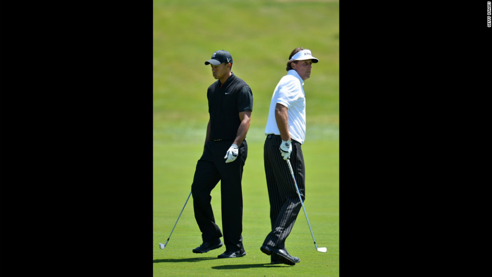 Tiger Woods and Phil Mickelson walk past one another during the second round.