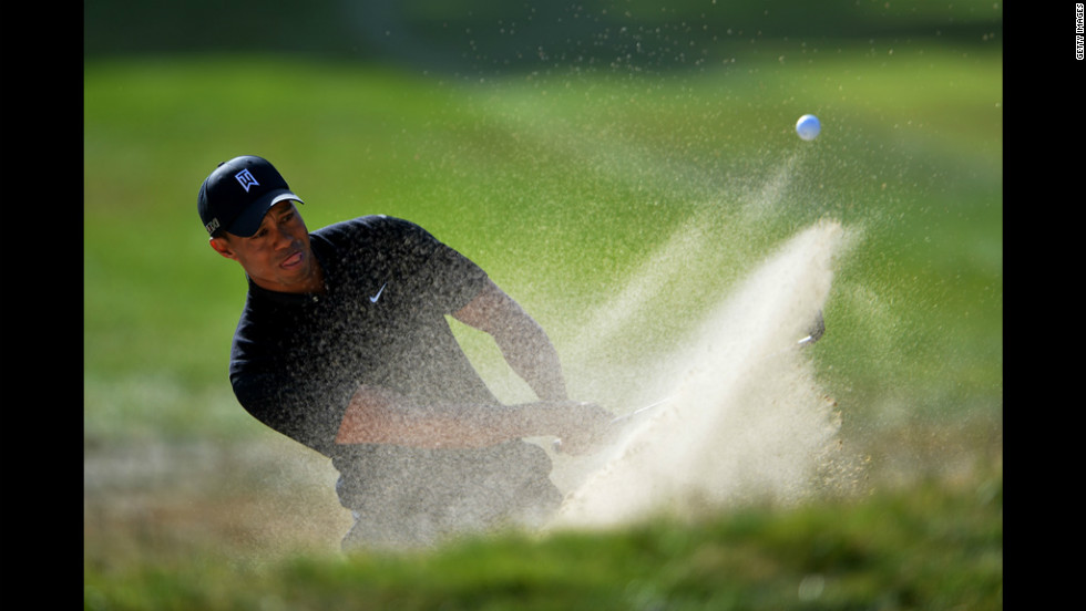  Tiger Woods plays a bunker shot on the 16th hole.