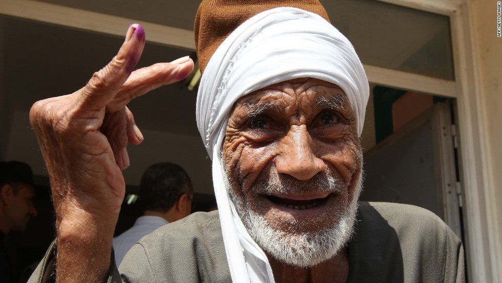 An elderly Egyptian man shows the indelible ink stain on his finger after voting on the first day of the second round of the historical presidential election at a polling station in the city of Zagazig.