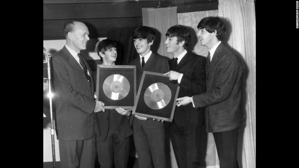 Sir Joseph Lockwood, chairman of EMI Music, presents The Beatles with two silver records for their albums &quot;Please, Please Me&quot; and &quot;With The Beatles,&quot; which reached 250,000 sales.