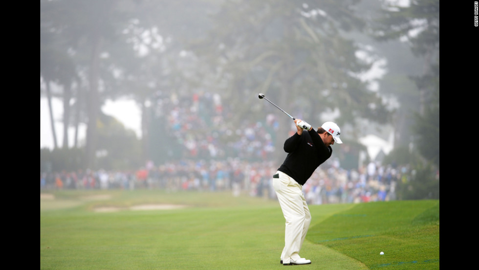Graeme McDowell hits his second shot on the sixth hole.
