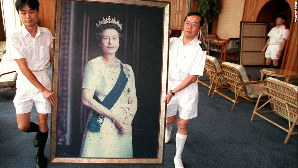 Two Royal Navy sailors carry a portrait of Queen Elizabeth through the British Forces&#39; Hong Kong headquarters as her pictures are taken down ahead of the handover of Hong Kong in 1997.