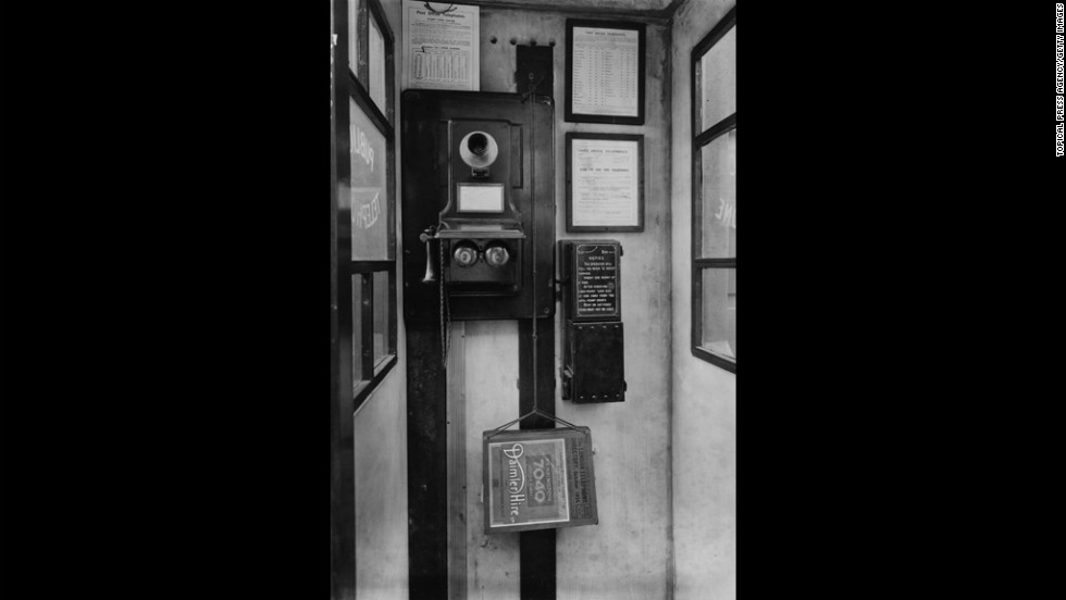 This 1924 phone booth in London features a wall-mounted phone with separate mouthpiece and receiver.