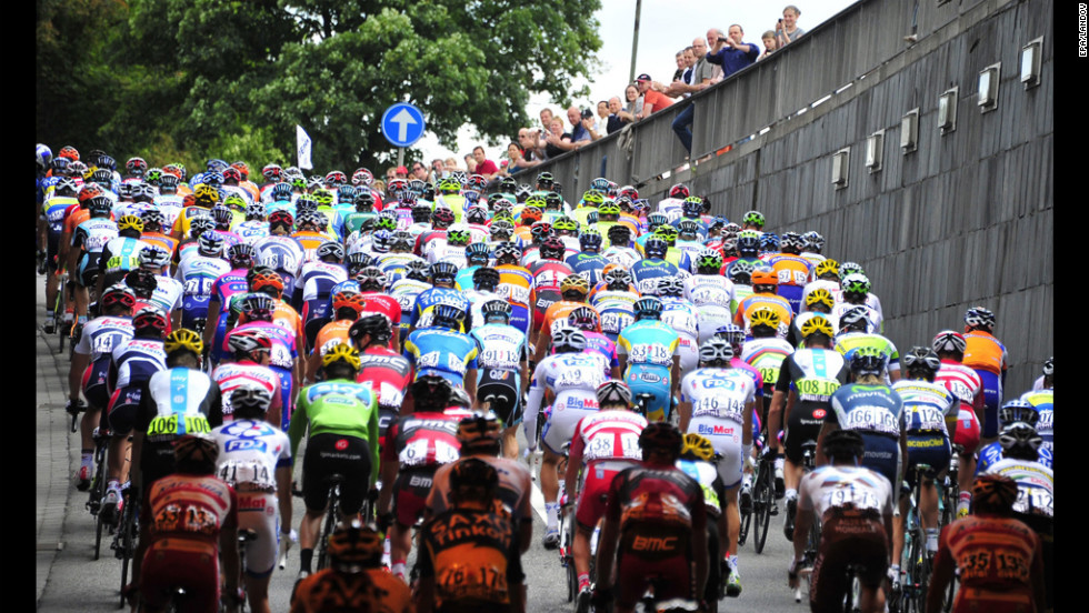 Fans peer over a railing as riders crest a small hill on Sunday.