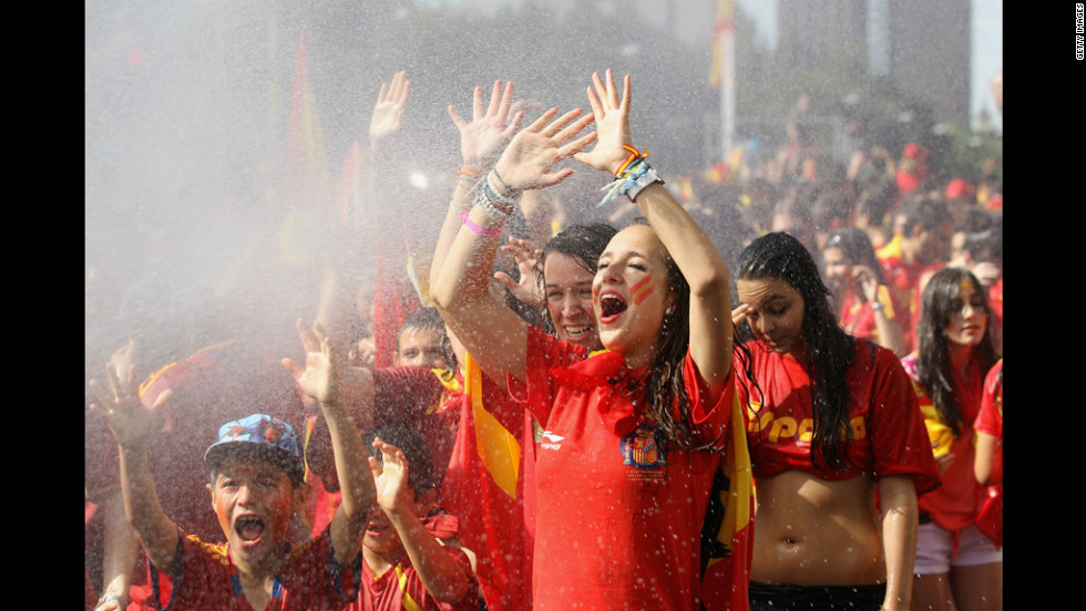 Supporters of Spain&#39;s national soccer team are hosed down before the team&#39;s victory parade in Madrid on Monday.