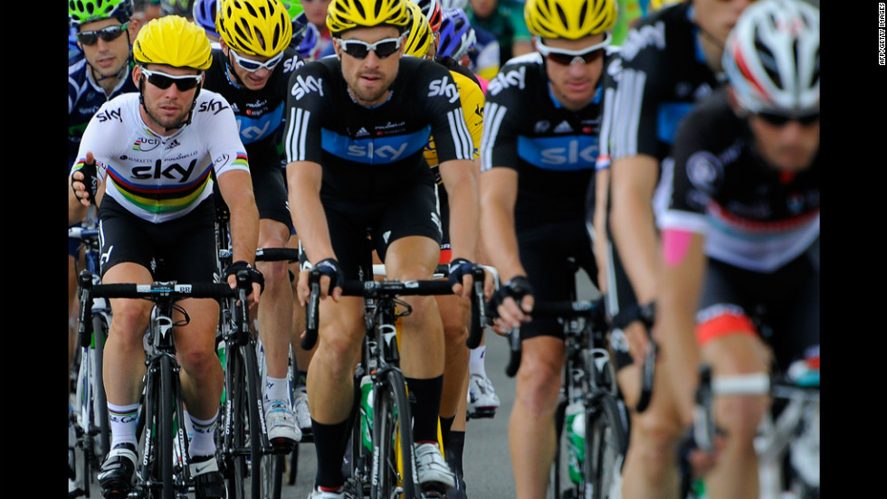 Mark Cavendish, left, rides with teammates from Britain&#39;s Team Sky, wearing yellow helmets signifying their lead in the team standings.