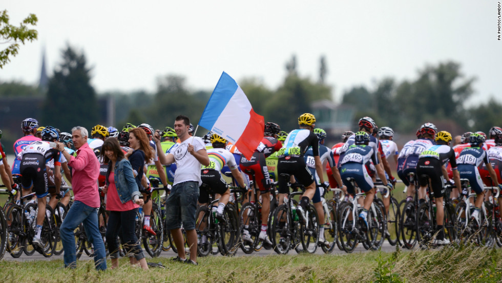 Fans wave the French flag as the peleton, led by team RadioShack-Nissan, rides past.