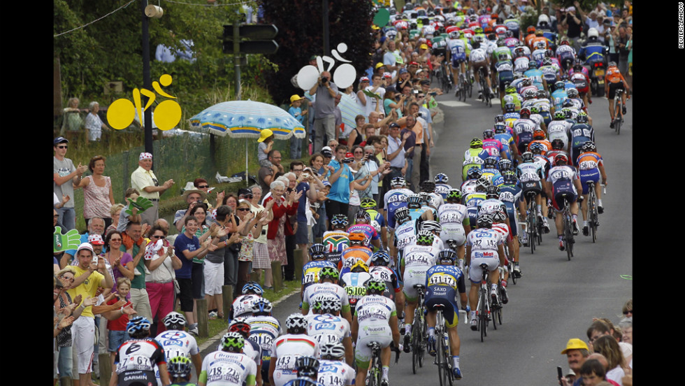 The pack of riders cycles past spectators during Stage 4.