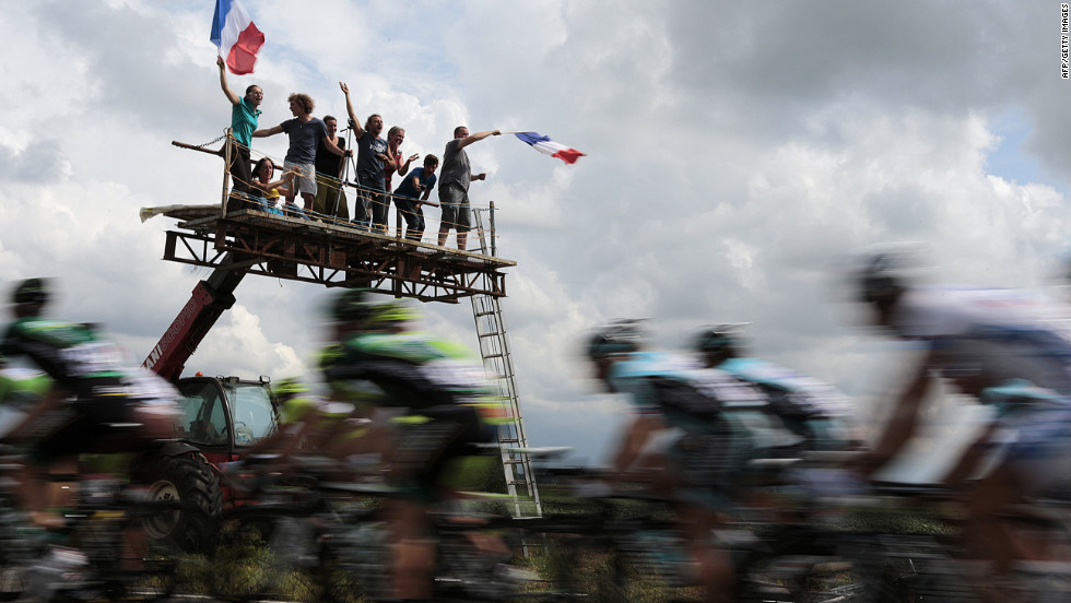 Fans wave French flags and cheer on riders Thursday as the main group passes on the way from Rouen, where Stage 5 of the race started, to Saint-Quentin.