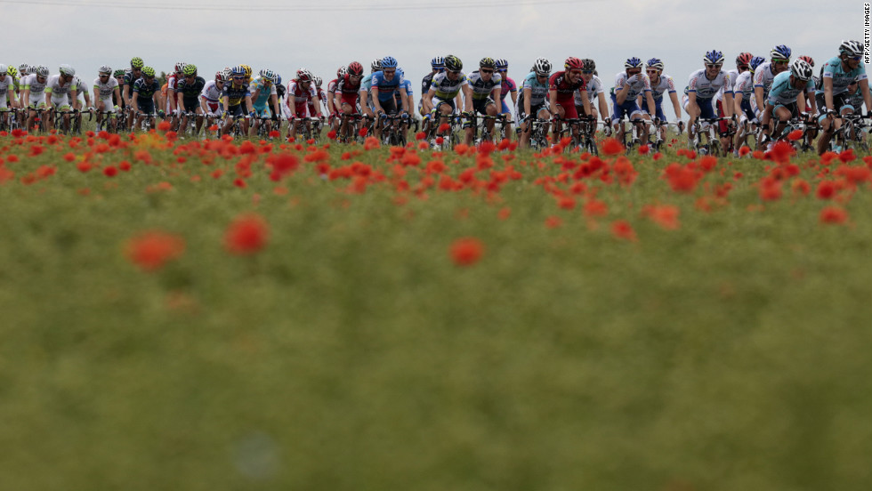 Riders pass a field of poppies as they race through the French countryside Thursday.