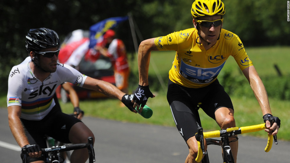 Overall race leader Bradley Wiggins, right, receives a water bottle handoff from Team Sky teammate Mark Cavendish on Wednesday.