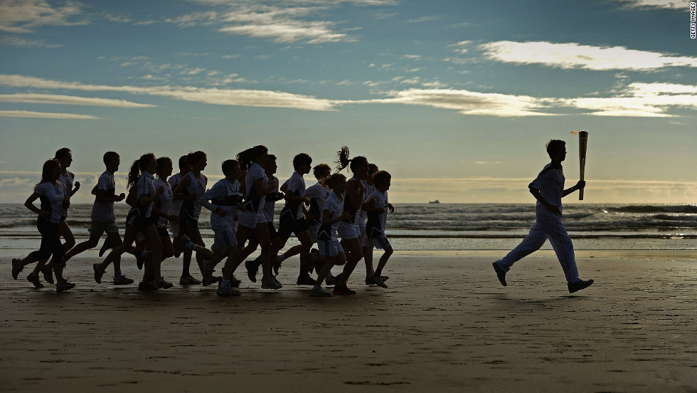 Joseph Forrester, 12, and children from Madras College run along West Sands in St. Andrews, Scotland, on June 13.