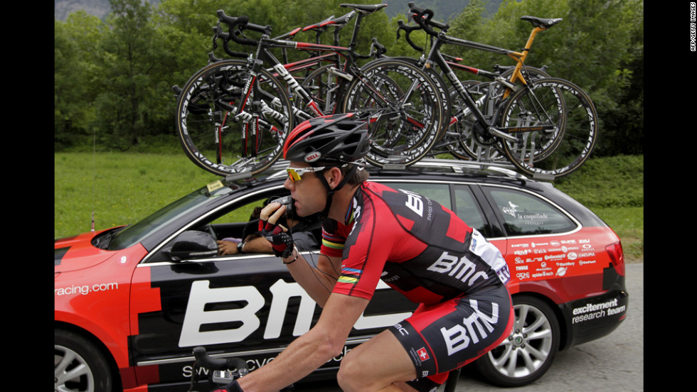 Australia&#39;s Cadel Evans checks technical problems with his radio-link earphones as he rides on Friday.