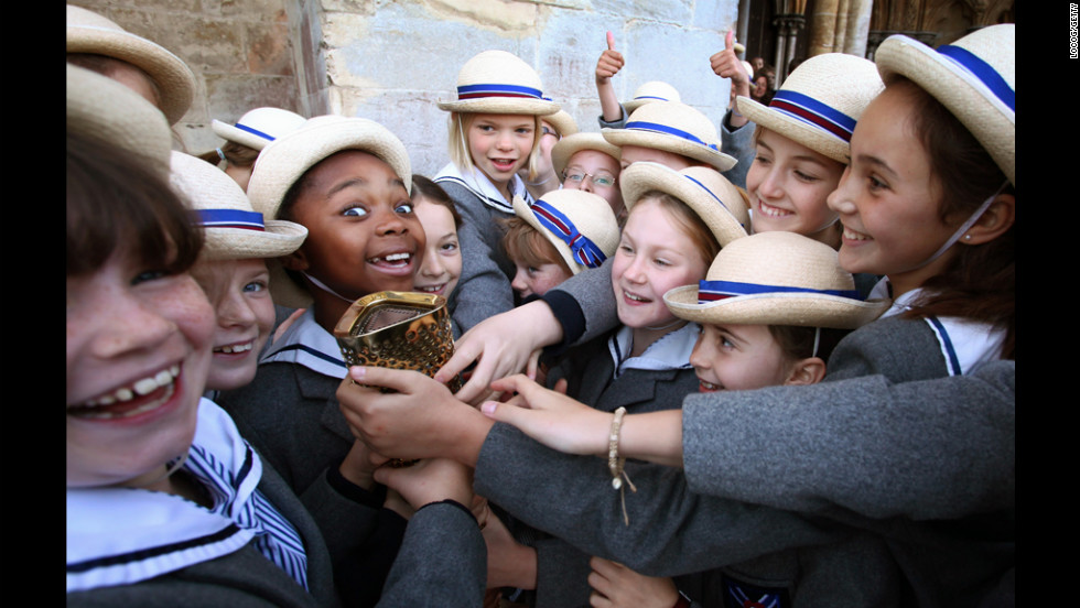 Schoolgirls outside Salisbury Cathedral on Thursday hold the torch carried by retired sprinter and four-time gold medal winner Michael Johnson.