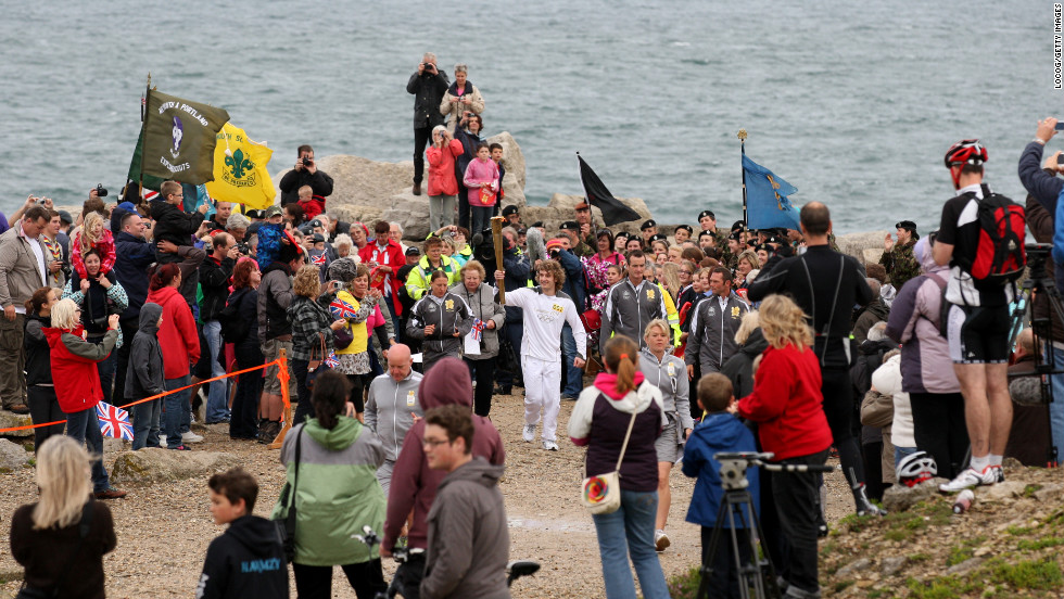 Thomas Mules carries the Olympic flame on Pulpit Rock, Portland Bill, on Friday, July 13.  