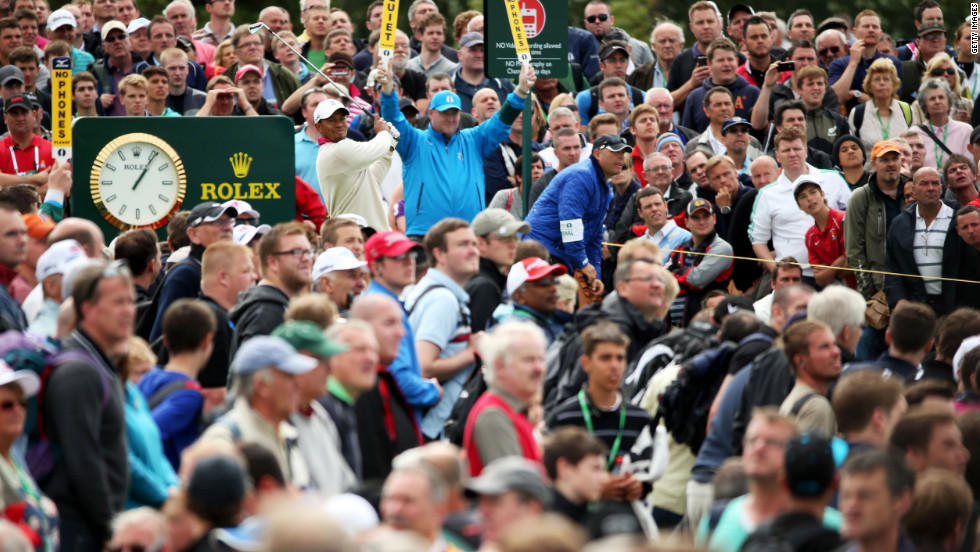 Amid a sea of spectators, Woods plays a shot to the green on the 14th hole Thursday.