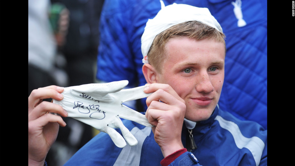 Jason Blue of Bristol poses with a golf glove given to him by Rory McIlroy after he was struck by his golf ball on Thursday.