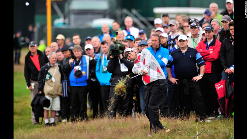 Adam Scott of Australia plays out of the rough on the second hole Thursday under the watchful eyes of spectators.