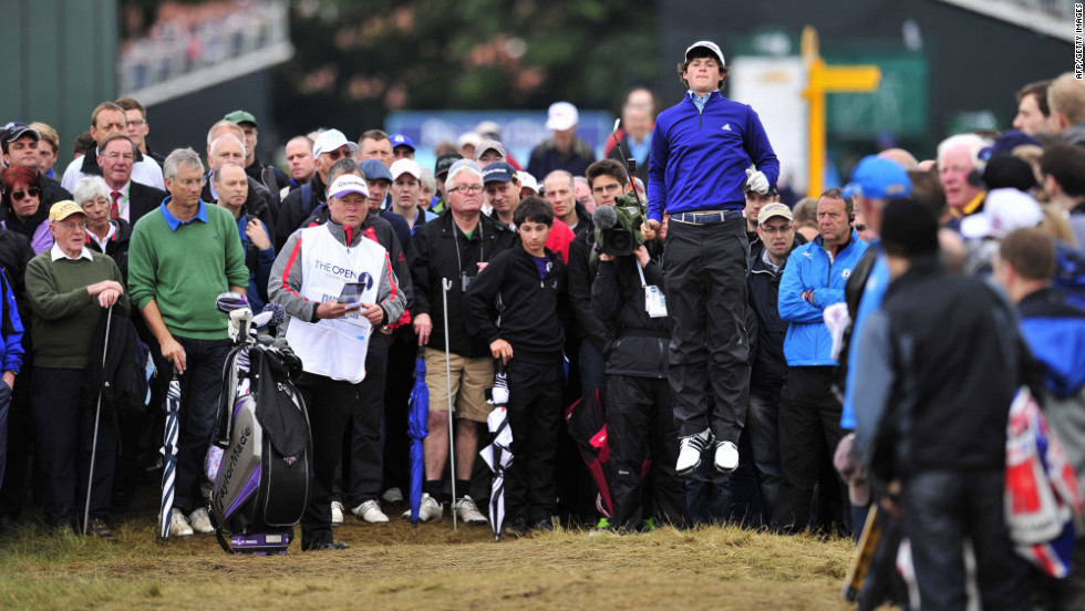 Amateur golfer Alan Dunbar of Northern Ireland leaps up to get a better view on the second hole during the first round of play Thursday.