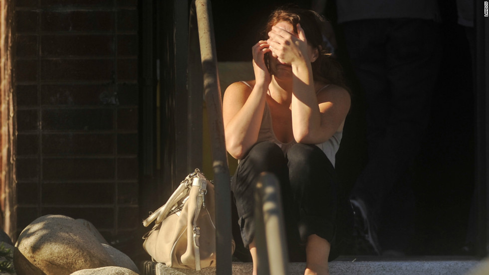 A woman waits for news outside Gateway High School, a few blocks from the scene of the shooting at the Century Aurora 16.