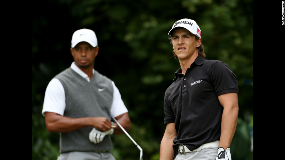 Olesen watches his tee shot on the first hole as Woods prepares to play.