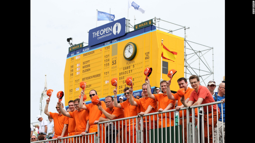 Fans of young American star Rickie Fowler fans pose in the bleachers at No. 18, dressed in their hero&#39;s customary bright, monochrome colors.